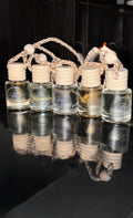 Set of small glass bottles with cork stoppers arranged in a basket on a reflective black surface.