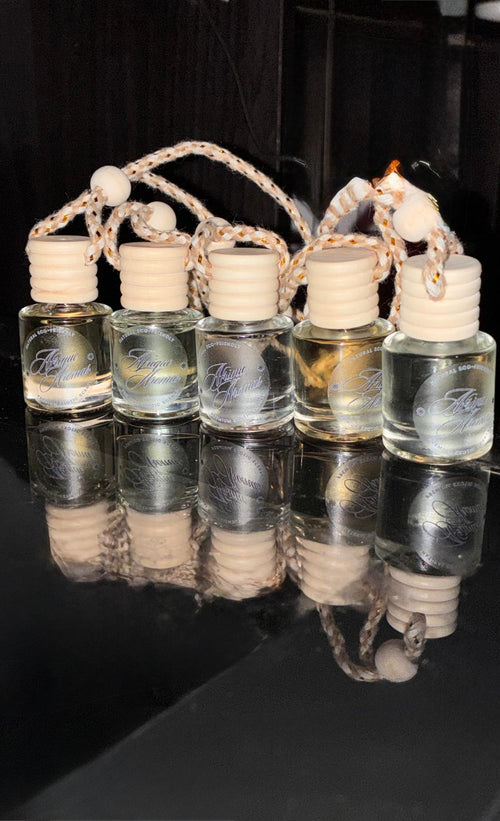 Set of small glass bottles with cork stoppers arranged in a basket on a reflective black surface.